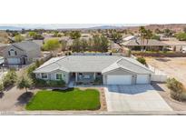 Charming single-story home featuring a well-manicured lawn and a three-car garage at 1395 Logandale Dr, Logandale, NV 89021