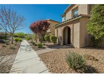 Inviting two-story home featuring an arched entryway, low maintenance landscaping, and a well-maintained walkway at 3158 Teaderman Walk, Henderson, NV 89044