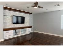 Bright living room featuring a large built-in entertainment center with shelving and hardwood floors at 4912 Capo Gallo St, Las Vegas, NV 89130