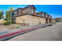 Exterior angle shot of a 2-story home with a multiple-car garage and beige and brown stucco at 8324 W Charleston Blvd # 2022, Las Vegas, NV 89117