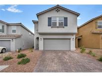 Charming two-story home with a brick driveway and a two-car garage at 9983 Cluny Ave, Las Vegas, NV 89178