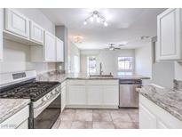Bright kitchen features stainless steel appliances, granite counters, and white cabinets at 1634 Clint Canyon Dr, Henderson, NV 89002