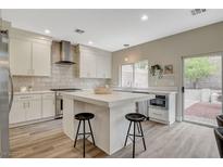 Bright kitchen features a center island, stainless steel appliances, and direct access to the outdoor space at 2033 Shining Feather Ln, Las Vegas, NV 89134