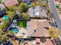 Expansive backyard with pool, lush landscaping, and a covered patio, ideal for outdoor living at 4481 Grey Spencer Dr, Las Vegas, NV 89141