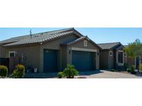 Home exterior showcases a three-car garage and desert landscaping, plus paver driveway at 5096 Maverick, Las Vegas, NV 89130