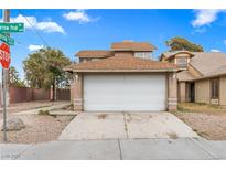 Two-story home with a two-car garage and low maintenance landscaping in a residential neighborhood at 6652 Wheelbarrow Peak Dr, Las Vegas, NV 89108