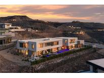 A modern and architecturally stunning multi-level home with clean lines and a pool sits amongst desert landscaping at 709 Dragon Peak Dr, Henderson, NV 89012