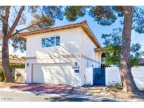 Charming two-story home with a garage, red brick driveway, and well-maintained yard, under a clear sky at 2204 Plaza De La Candela, Las Vegas, NV 89102