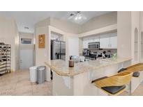 Bright kitchen features modern appliances, granite counters, and bar seating area at 5000 Red Rock St # 241, Las Vegas, NV 89118