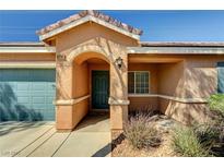Inviting front entrance featuring an arched entryway, low maintenance landscaping, and a two-car garage at 5292 Cholla Cactus Ave, Las Vegas, NV 89141