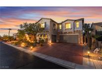 Charming two-story home with a brick driveway, stone accents, and a well-maintained front yard at sunset at 872 Timber Walk Dr, Henderson, NV 89052