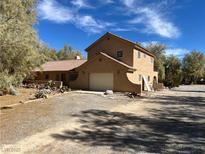 A two-story home featuring a large attached garage and tile roof situated on a large lot at 1851 Pinto Ln, Pahrump, NV 89060