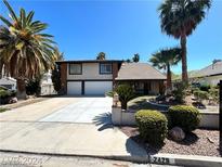 Charming two-story home featuring a spacious driveway, attached garage, and mature landscaping with palm trees at 2428 Greens Ave, Henderson, NV 89014