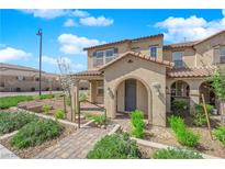 Charming two-story home with an arched entryway and well-maintained landscaping at 2449 Padulle Pl, Henderson, NV 89044