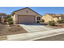 Beige single-story home featuring a two-car garage and desert landscaping at 2557 Terrytown Ave, Henderson, NV 89052