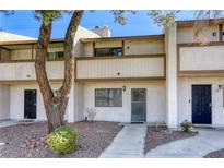Two-story condo showcasing a covered balcony and an inviting front entrance, complemented by mature tree at 5242 Osman Ct # 57, Las Vegas, NV 89103