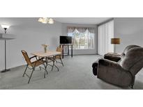 Cozy living room with plush recliner, small dining table, and bright window view at 7123 S Durango Dr # 204, Las Vegas, NV 89113