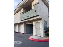 Charming townhouse featuring an open garage and an enclosed balcony with a neutral stucco exterior at 7139 S Durango Dr # 218, Las Vegas, NV 89113