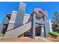 Two-story condo featuring stucco walls, red trim, and a private entrance at 8600 W Charleston Blvd # 2089, Las Vegas, NV 89117