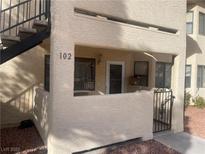 Inviting condo entrance with stairs, security door, and neutral stucco finish at unit 102 at 1112 Observation Dr # 102, Las Vegas, NV 89128