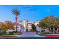 Elegant two-story home boasts a red tile roof, arched entryway, and mature desert landscaping at 2660 Mirabella St, Henderson, NV 89052