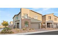 Two-story home featuring modern architecture, neutral colors, stone accents, and a well-maintained front yard at 290 Mount Williamson St, Henderson, NV 89015