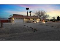 Charming single-story home boasts a well-maintained desert landscape and a spacious two-car garage at 2961 Ponderosa Ave, Pahrump, NV 89048