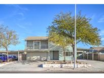 Two-story home with a balcony, two-car garage, and mature tree in the front yard at 401 Altamira Rd, Las Vegas, NV 89145