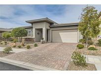 Charming single-story home featuring a brick driveway, a two-car garage, and a well-manicured front yard at 424 Heritage Bridge Ave, Henderson, NV 89011