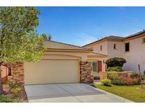 Charming single-Gathering home features an attached two-car garage with a brick-accented exterior and a well-manicured lawn at 4593 Weitzman Pl, Las Vegas, NV 89141