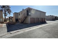 Tan apartment building with brown garages and stairwells on sunny day at 567 Roxella Ln # D, Las Vegas, NV 89110