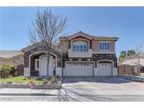Charming two-story home with a three-car garage, stone accents, and well-maintained landscaping under a clear sky at 6377 Elizabethtown Ave, Las Vegas, NV 89110