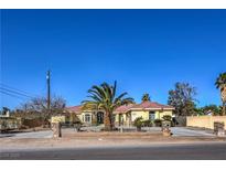 Charming single-story home with desert landscaping, mature palm tree, and gated driveway at 7945 La Cienega St, Las Vegas, NV 89123