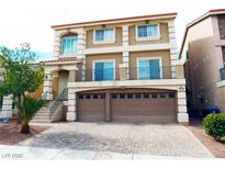 Two-story home featuring a balcony, a two-car garage and a landscaped front yard at 9739 Fox Estate St, Las Vegas, NV 89141