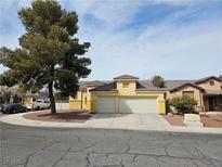 Charming single-story home featuring a two-car garage and a well-maintained front yard with mature tree at 6908 Fruit Flower Ave, Las Vegas, NV 89130