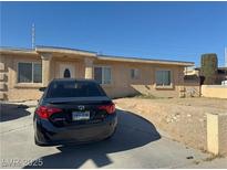 Single-story stucco home featuring a front yard with a desert landscape and a driveway at 1001 Fay Blvd, Las Vegas, NV 89108