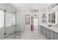 Modern bathroom featuring a glass shower, marble floors, and neutral gray tones at 1405 Bugle Boy Dr, Henderson, NV 89014