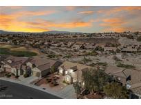 Sunset aerial view of a desert community with mature landscaping and a view of the mountains at 2920 Foxtail Creek Ave, Henderson, NV 89052