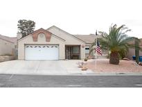 Charming single-story home with a two-car garage, desert landscaping, and an American flag at 7233 Alsop Ct, Las Vegas, NV 89156
