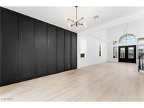 Bright, open living room with wood floors, contemporary lighting, and stylish black accent wall at 9795 La Cienega St, Las Vegas, NV 89183