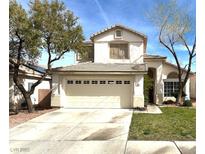 Charming two-story home showcasing a neutral facade, well-manicured lawn, and an attached two-car garage at 981 Leadville Meadows Dr, Henderson, NV 89052