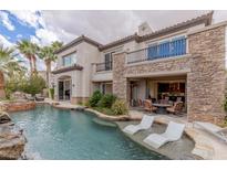 Beautiful outdoor pool with lounge chairs, water features, and a patio area, perfect for relaxing and entertaining at 2436 Grassy Spring Pl, Las Vegas, NV 89135