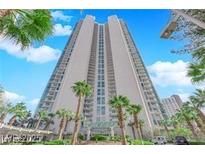 Stunning high-rise exterior with palm trees, lush landscaping, and a grand entrance under a clear blue sky at 322 Karen Ave # 2003, Las Vegas, NV 89109