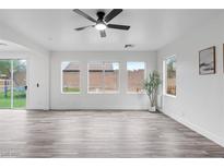 Bright living room with wood-look tile floors, ample natural light, and a modern ceiling fan at 4905 Madre Maria Ct, North Las Vegas, NV 89031