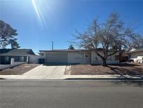 Single-story home featuring a two car garage and low maintenance landscaping at 5129 Sugarfoot Ave, Las Vegas, NV 89107