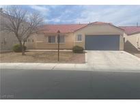 Charming single-story home featuring a two-car garage, desert landscaping, and a red tile roof at 6615 Montezuma Castle Ln, North Las Vegas, NV 89084