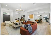 Spacious living room with modern furnishings, hardwood floors, and a stunning chandelier at 800 Jody Brook Ct, Las Vegas, NV 89145