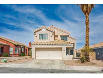 Two-story home featuring a two-car garage, desert landscaping and a beige stucco exterior at 938 Carnival Ave, Las Vegas, NV 89123