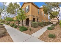 Inviting two-story home boasts stone accents, manicured landscaping, and a welcoming front porch with stone columns at 2376 Via Firenze, Henderson, NV 89044