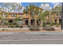 Charming townhome featuring desert landscaping, stone accents, and neutral color scheme at 2376 Via Firenze, Henderson, NV 89044